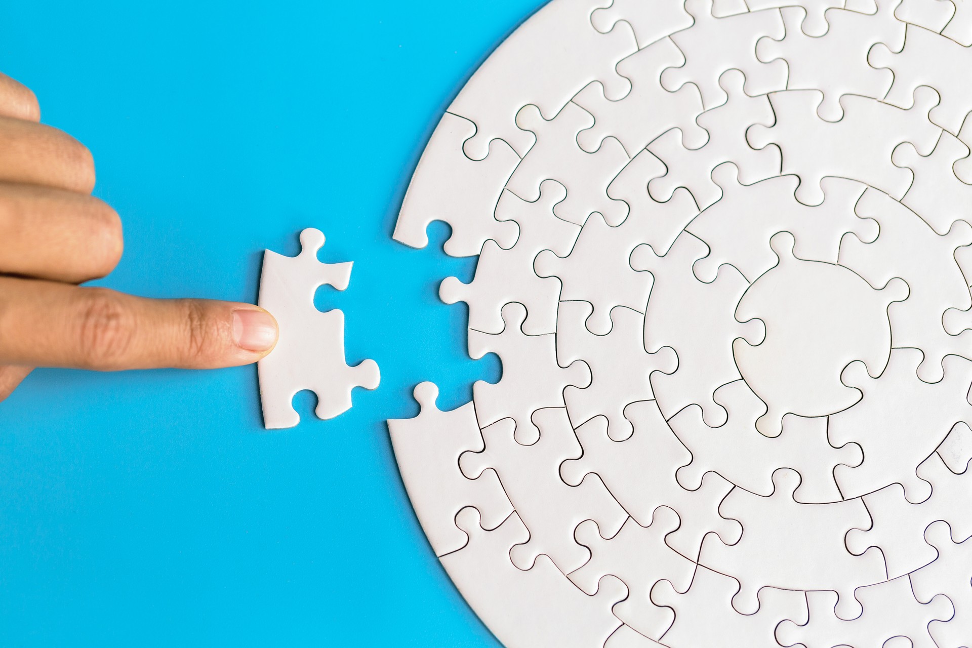 Hand put the last piece of jigsaw puzzle to complete the mission. Completing final task, missing jigsaw puzzle pieces and business concept with a puzzle piece missing.